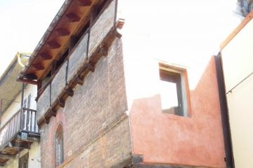 Casa Aschieri sorretta dalle colonne in pietra che poggiano su una terrazza rialzata un tempo luogo di commercio